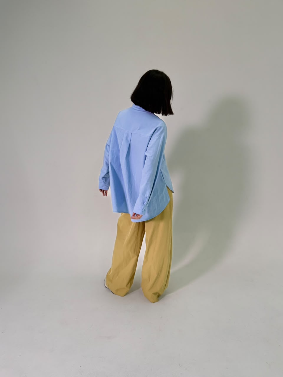 Camisa azul oversized com calça mostarda (detalhe)